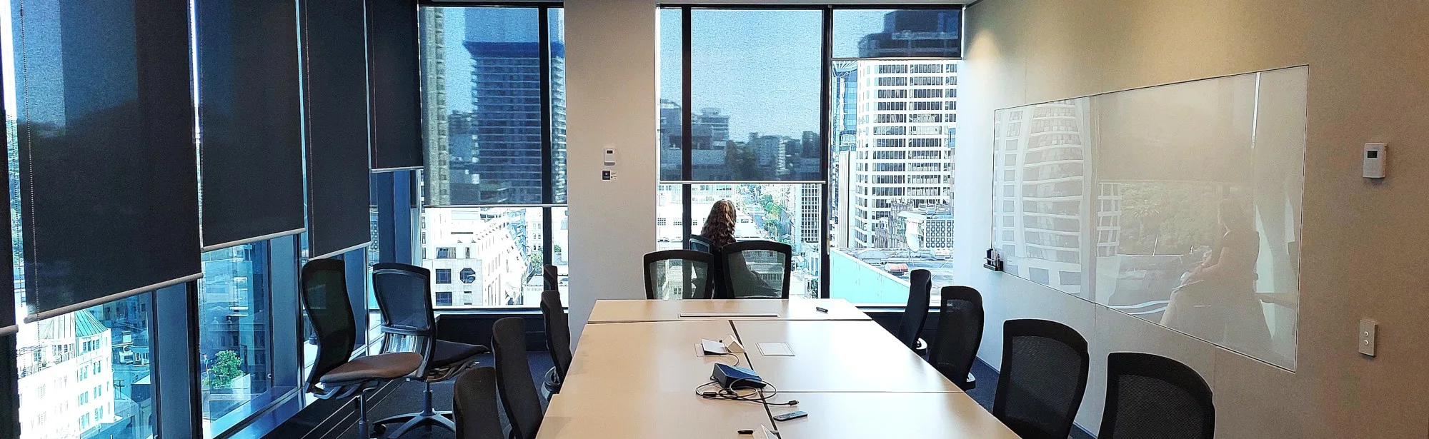 boardroom with city view and 2 glass whiteboards side by side inset in acoustic wall covering