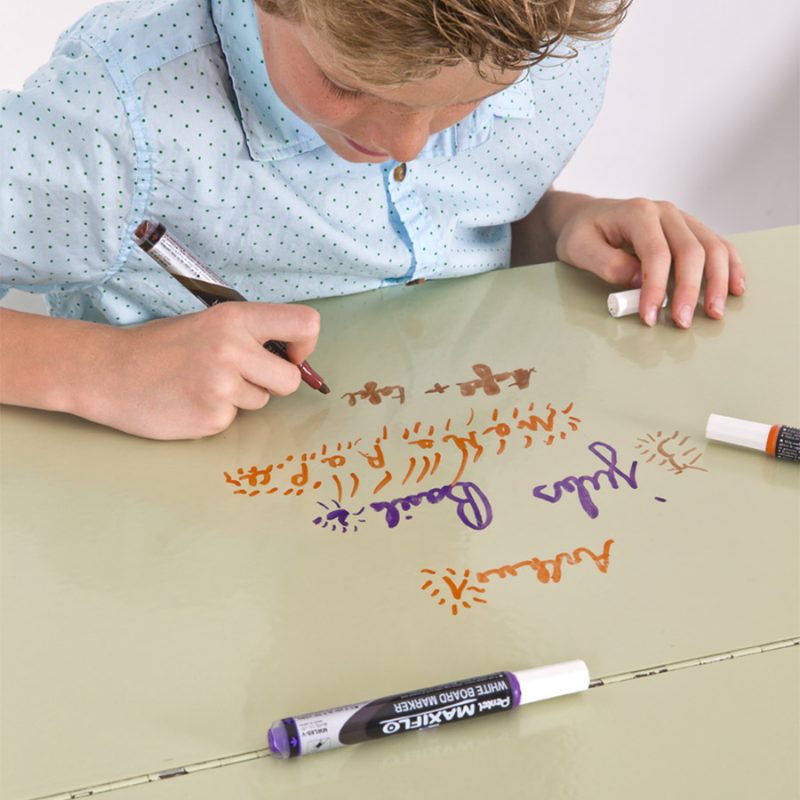 Child writing on desk with smart self-adhesive whiteboard film clear