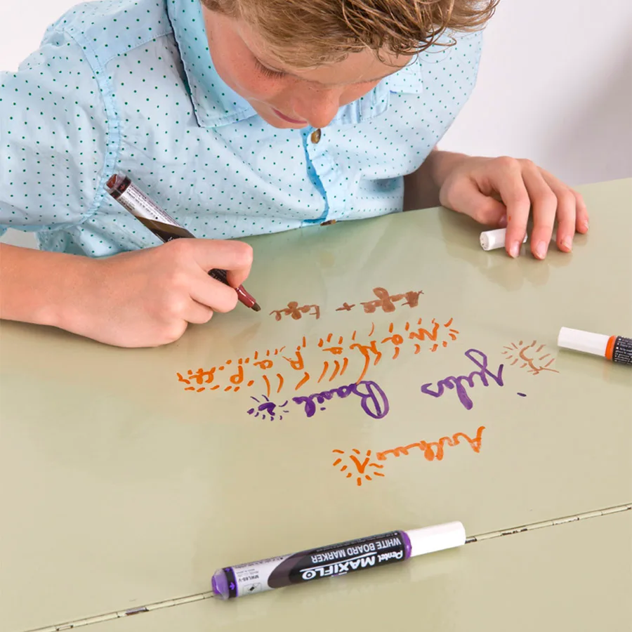 Child writing on desk with smart self-adhesive whiteboard film clear