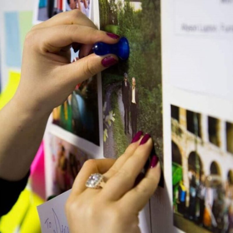 Neodymium magnetic buttons and pins used to hold photos on wall