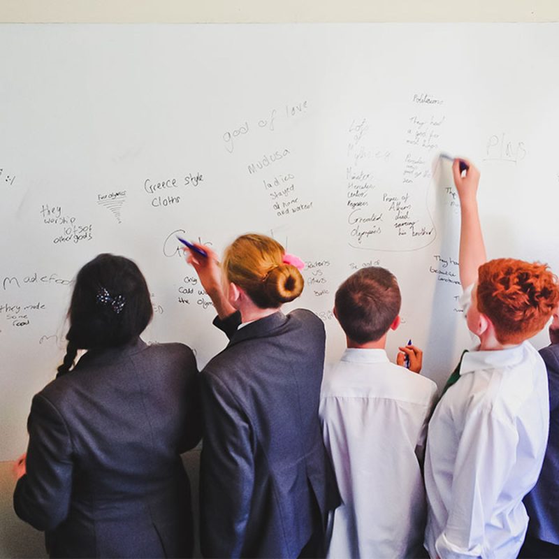 Students in school using whiteboard wall in lessons painted in smarter surfaces smart whiteboard paint